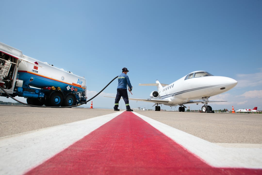 Business jet refueling on airport ramp with fuel truck, highlighting sustainable aviation fuel adoption in business aviation 2025.